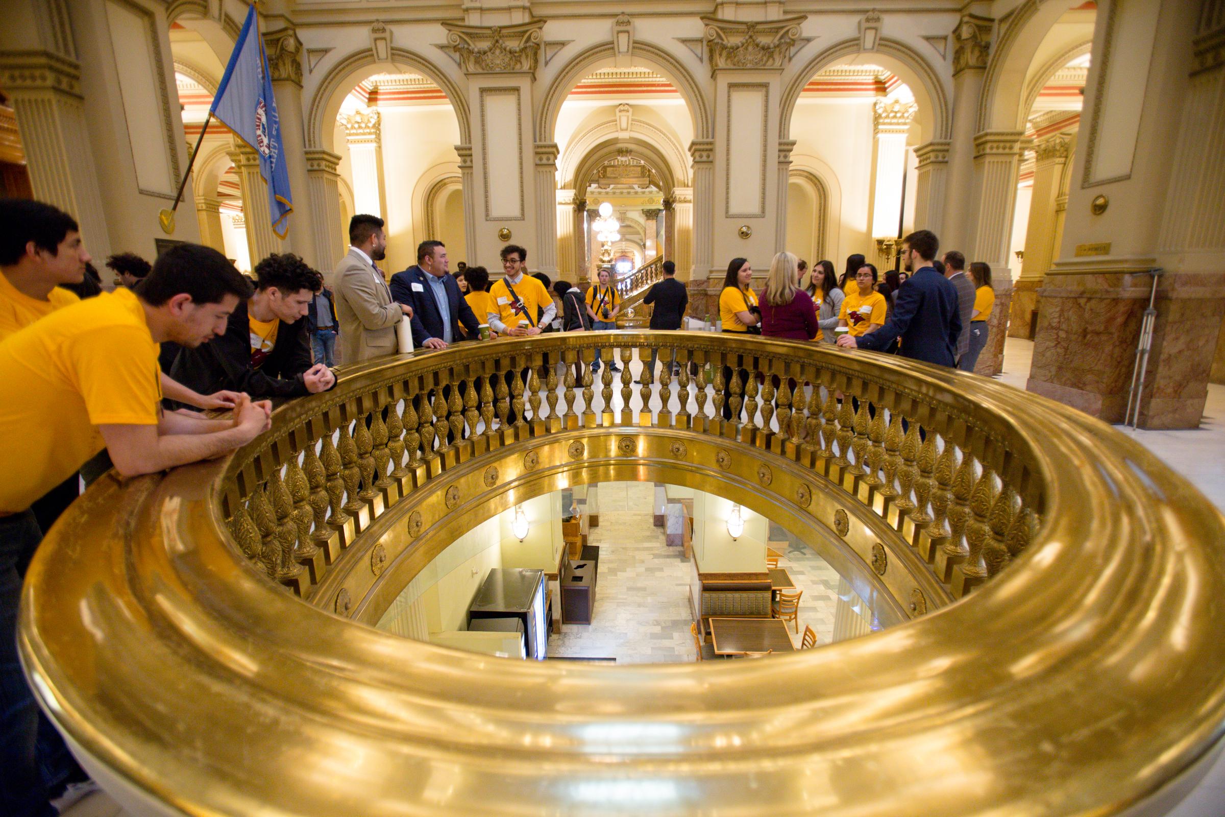 Students peering over a balcony at the state capitol.